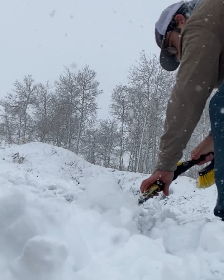 Shoveling snow off the container roof during field work